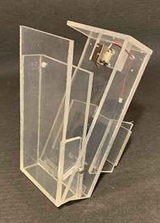 A clear plastic box with a red wire attached to it.