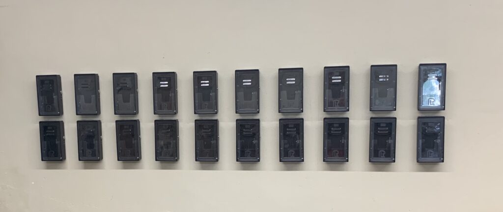 A wall with many different sized black switches.