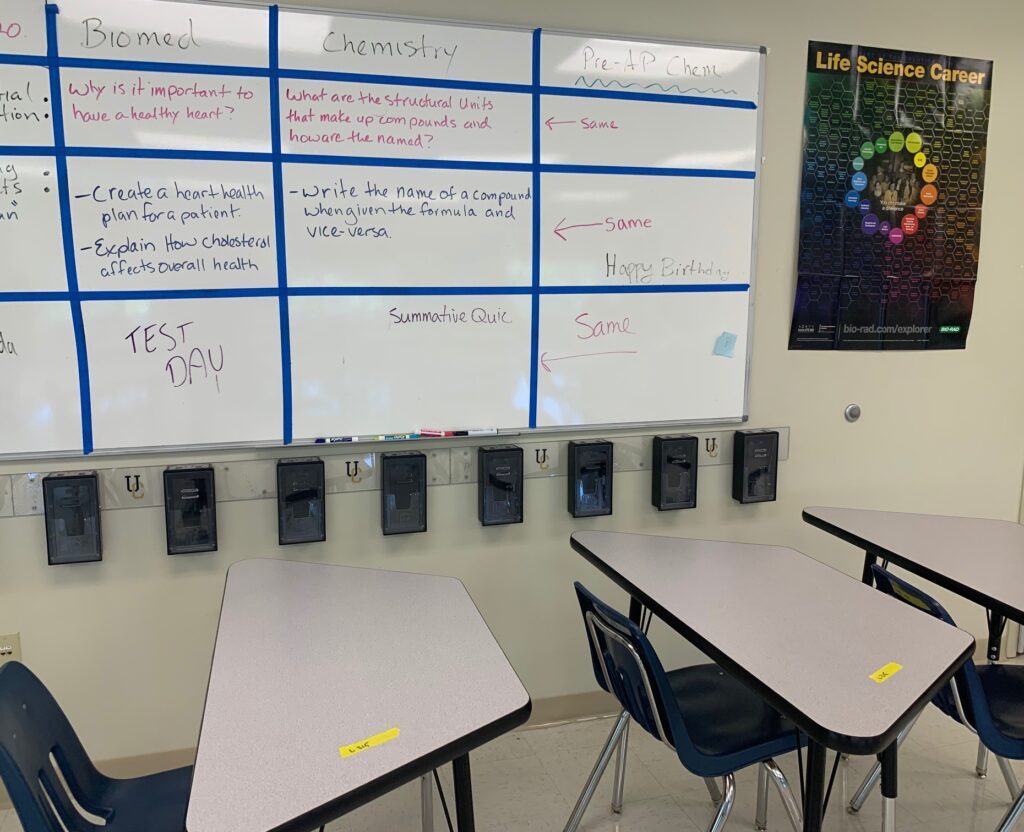 A classroom with two desks and a whiteboard
